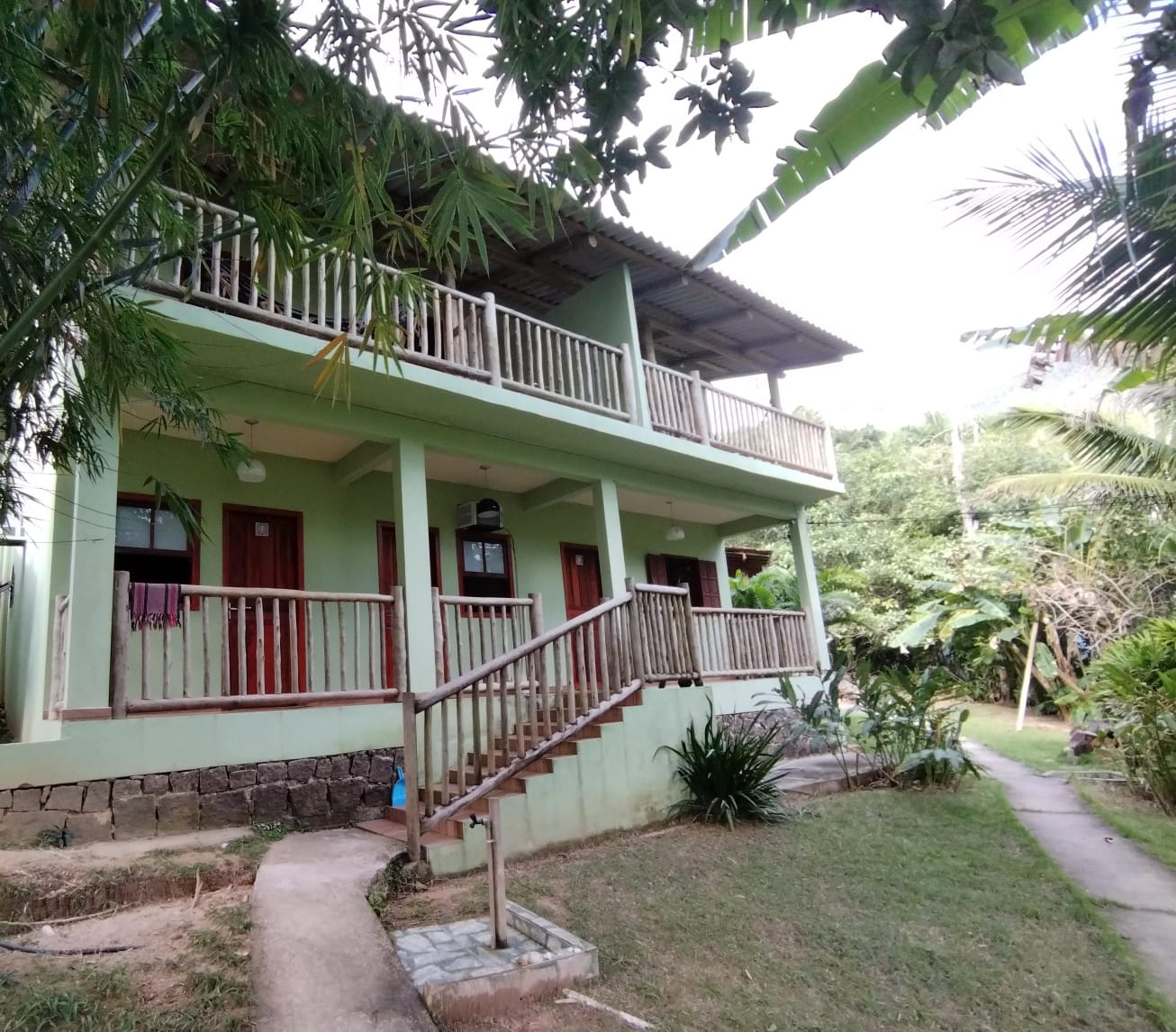 Fachada da Hospedagem Pão de Açúcar entre árvores